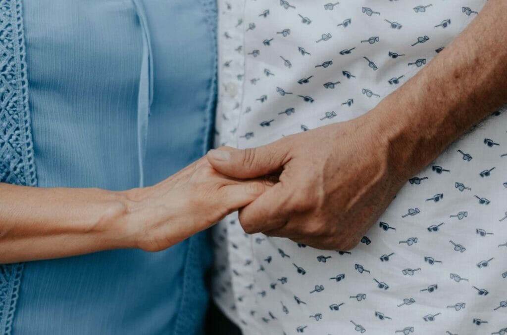 A close-up of two people holding hands.