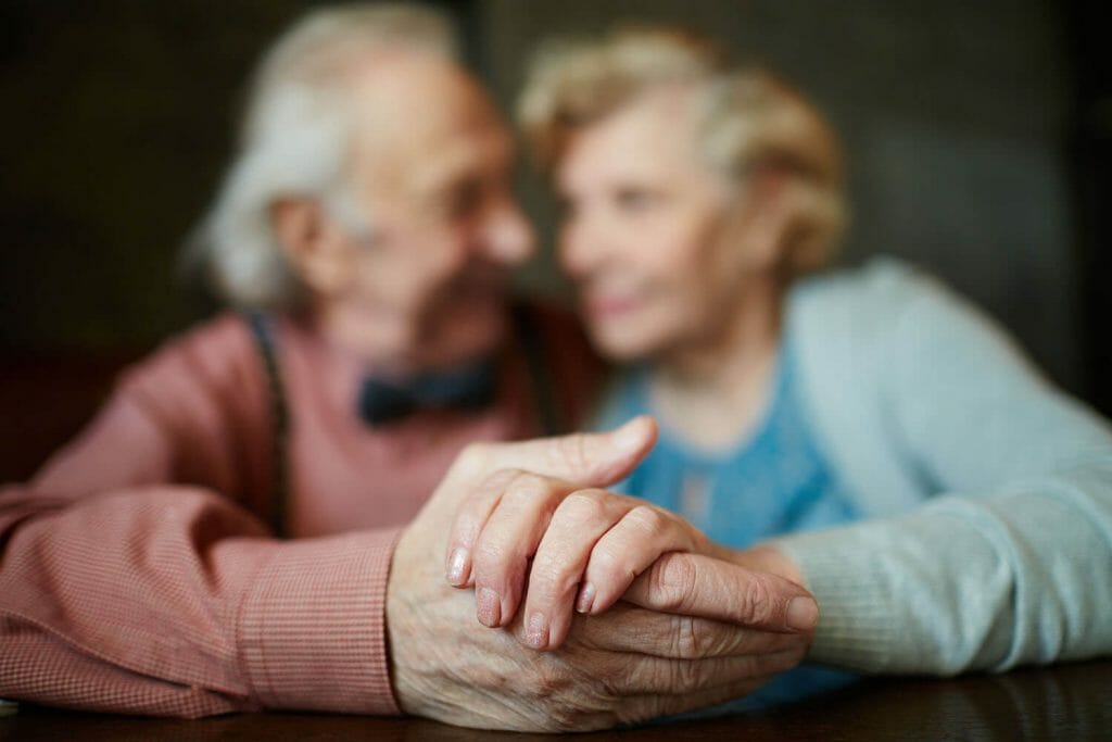 closeup image of a senior couples held hands.
