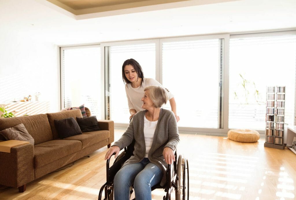 image of senior woman in a wheel chair with a young woman pushing her chair