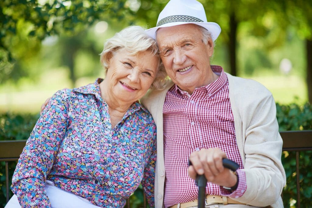 senior couple sitting on a bench in a park setting