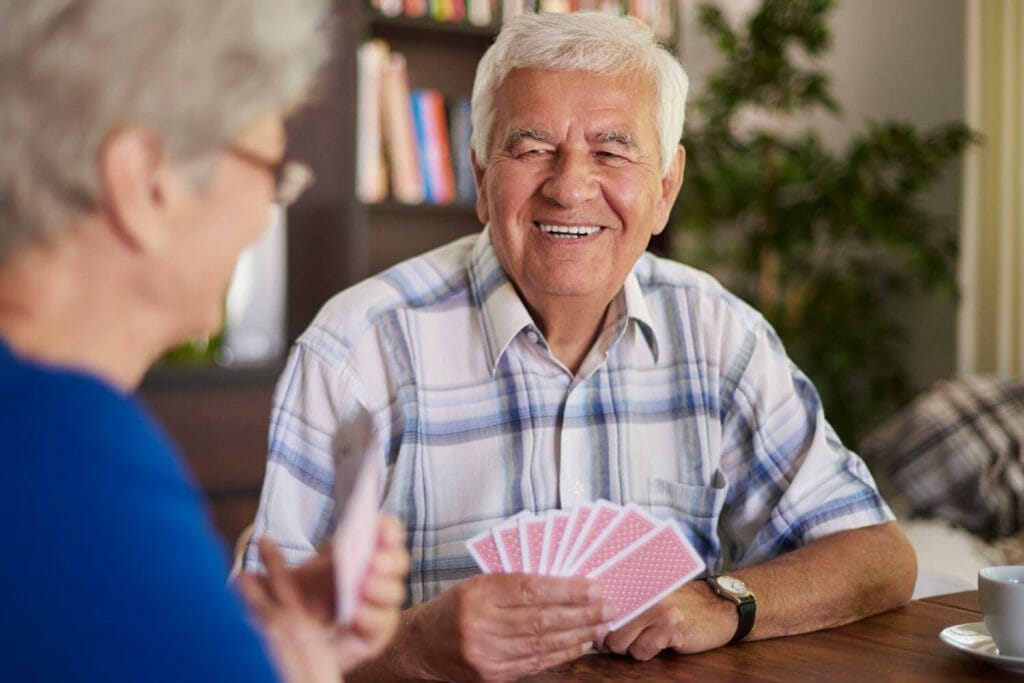 older man with an older woman playing cards.