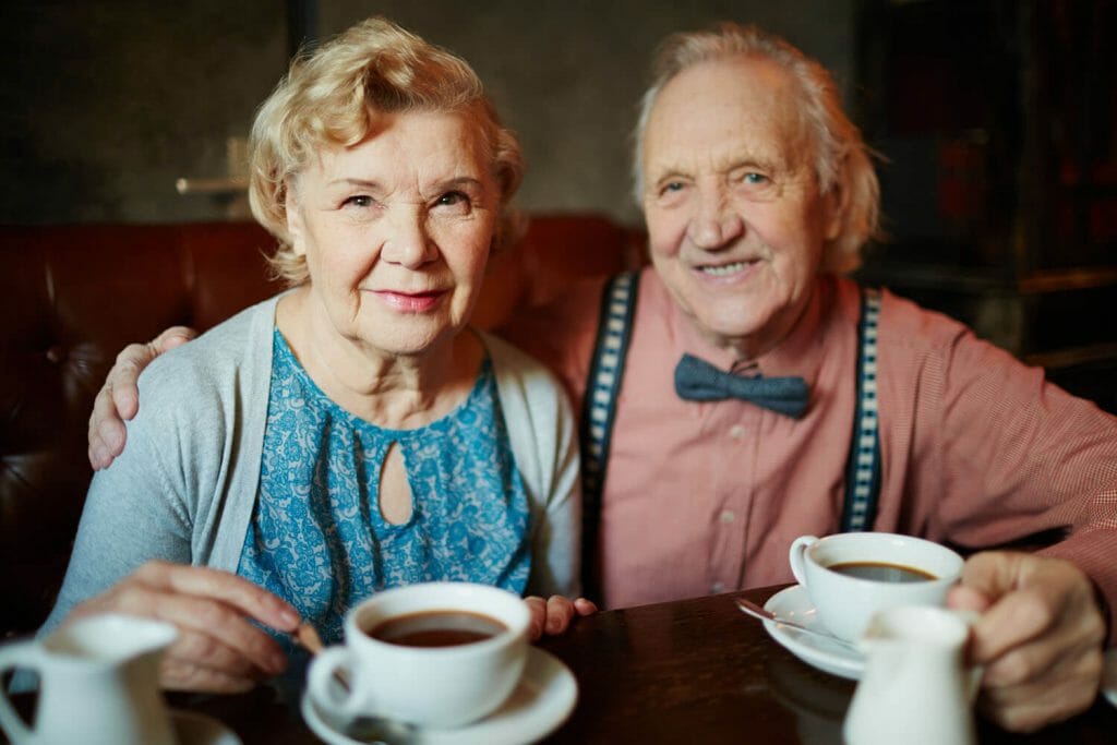 Senior couple drinking coffee together with the man wearing a bow tie