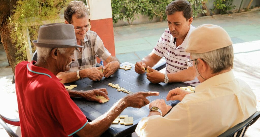 group of senior men playing dominoes together