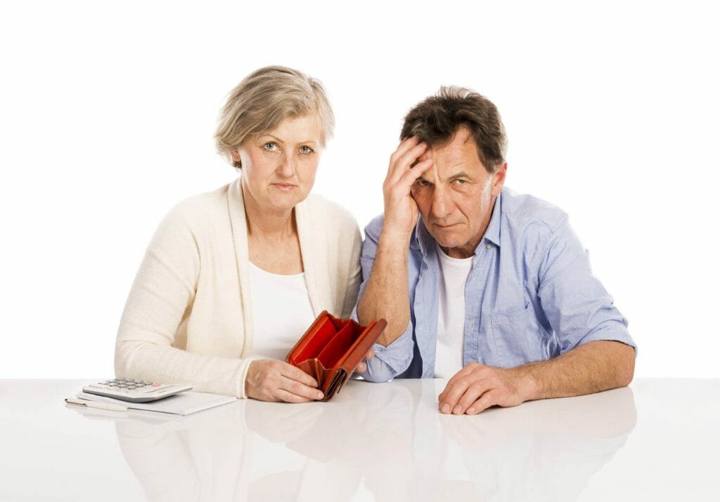 stressed out senior couple sitting with an empty wallet.